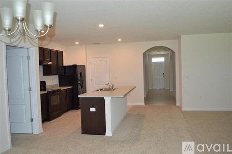 A kitchen with a sink and a refrigerator.