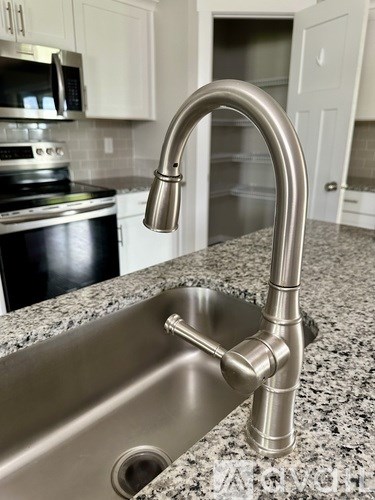 A kitchen sink with a chrome faucet.