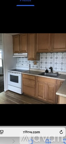 A kitchen with wooden cabinets and a white stove top oven.
