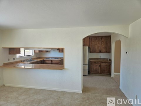 A room with a kitchen island and cabinets in the background.