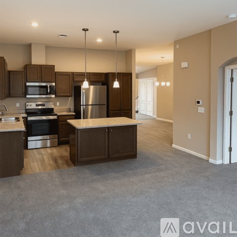 A kitchen with brown cabinets and a stainless steel refrigerator.