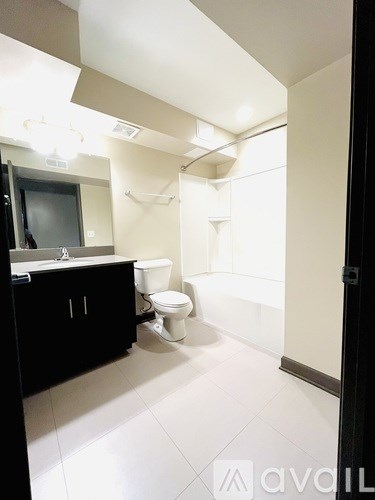 A bathroom with a toilet, sink, and mirror.