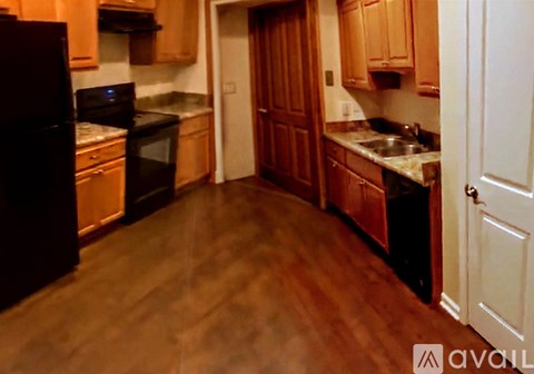 A kitchen with wooden cabinets and a black oven.