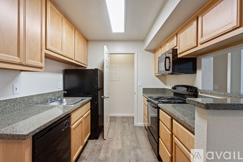 A kitchen with wooden cabinets and black appliances.