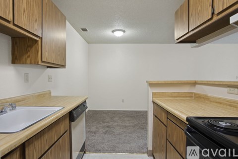 A kitchen with wooden cabinets and a white sink.