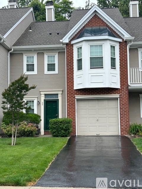A house with a garage door and a driveway in front.