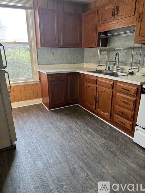 A kitchen with wooden cabinets and a white fridge.