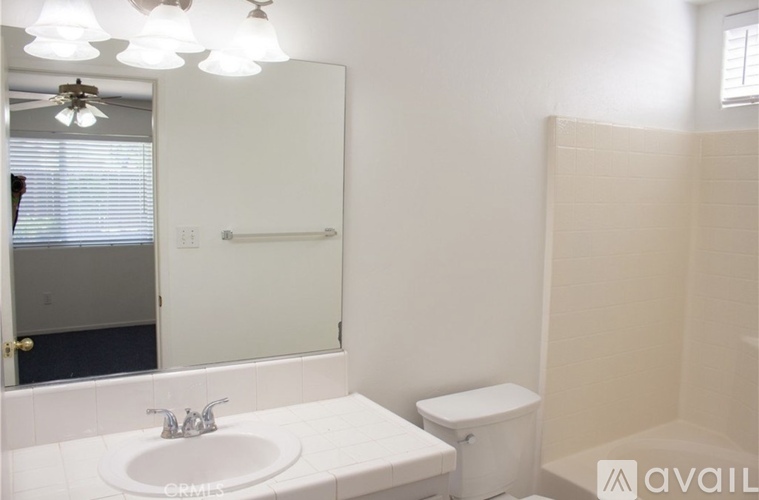 A bathroom with a sink, toilet, and shower.