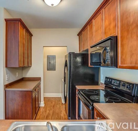 A kitchen with wooden cabinets and black appliances.