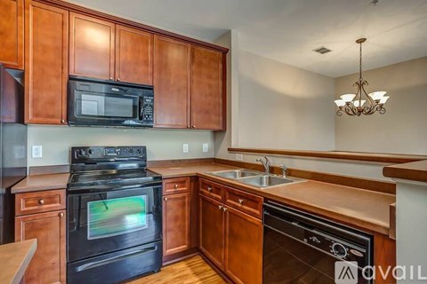 A kitchen with wooden cabinets and a black stove top oven.