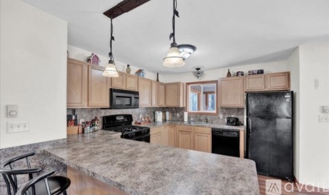 A kitchen with wooden cabinets and a granite countertop.