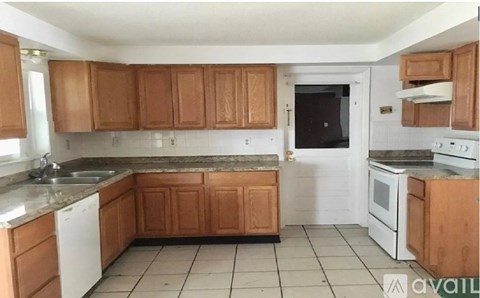 A kitchen with wooden cabinets and white appliances.