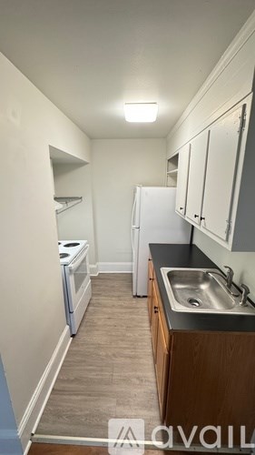 A kitchen with a sink and a refrigerator.