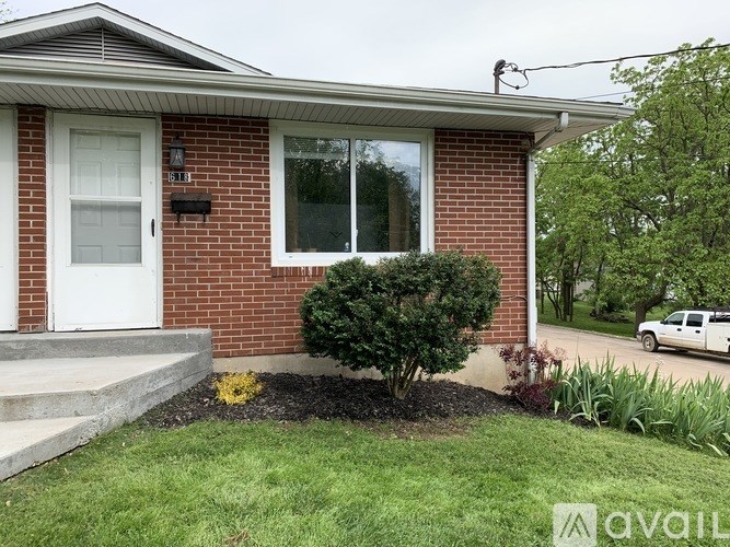 A house with a white door and a small bush in front.