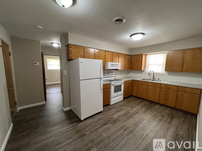 A kitchen with white appliances and wooden cabinets.