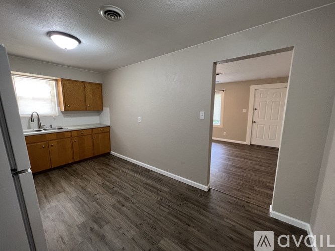 A kitchen with wooden cabinets and a refrigerator.