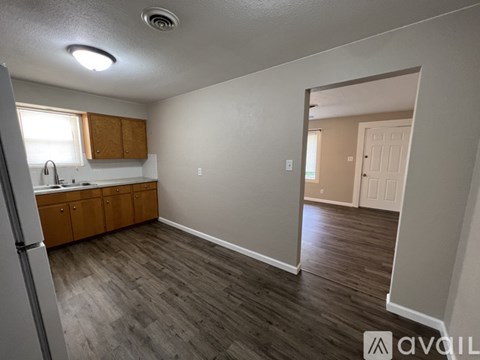 A kitchen with wooden cabinets and a refrigerator.