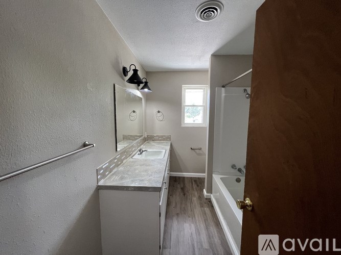 A bathroom with a toilet, sink, and mirror.