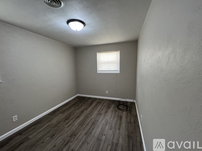 A room with a wooden floor and a window.
