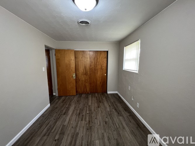 A room with wooden floors and a ceiling light fixture.