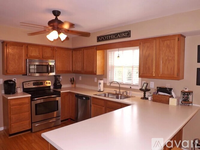 A kitchen with wooden cabinets and a white countertop.