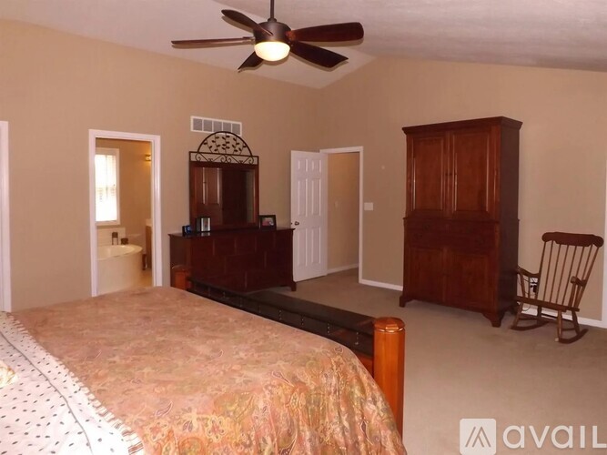 A bedroom with a bed, dresser, and chair.