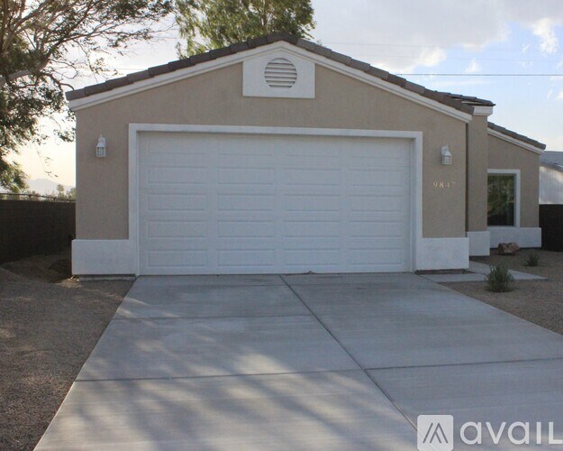 A beige garage with a white door and a small window above it.