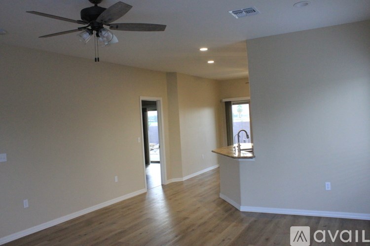 A spacious room with a ceiling fan and wooden flooring.