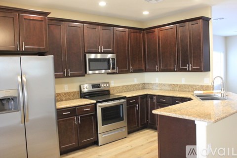 A kitchen with brown cabinets and stainless steel appliances.