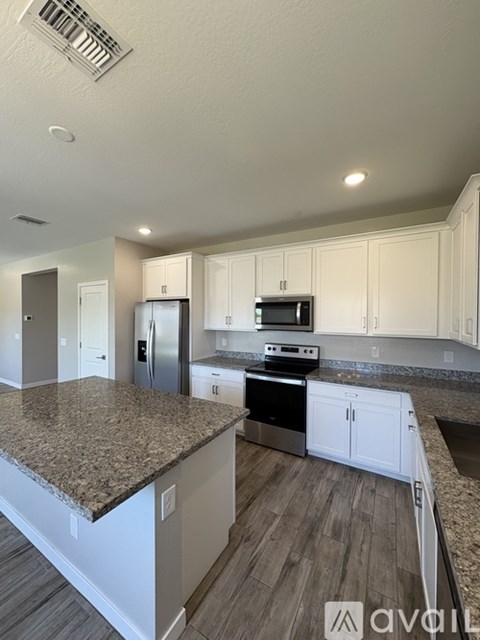 A kitchen with granite countertops and white cabinets.