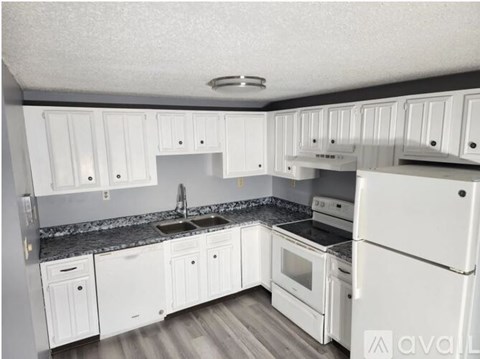A kitchen with white cabinets and appliances.