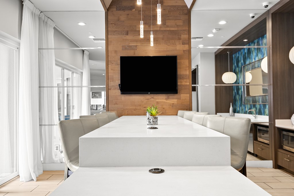 A modern dining room with a large table and chairs.