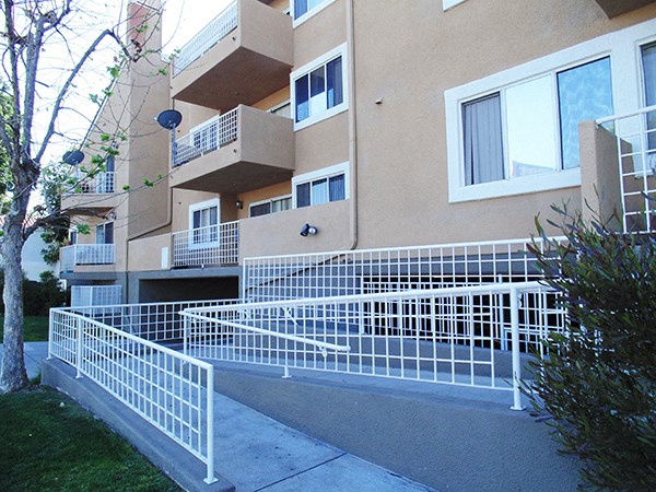 the façade of an apartment building with white fences