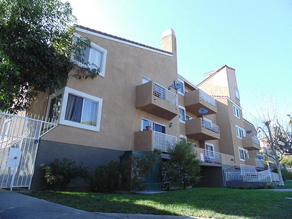 the exterior of an apartment building with stairs and balconies