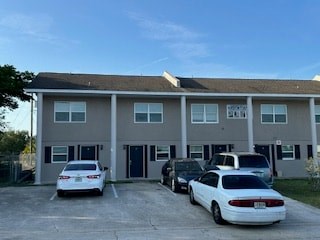 A white car is parked in front of a building.