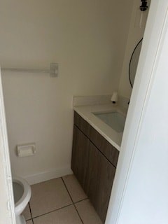 A white toilet is in a small bathroom with a sink and a mirror.