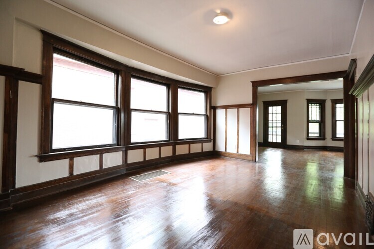 A room with wooden floors and large windows.