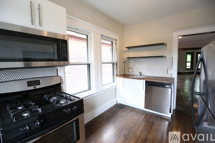 A kitchen with a black stove top oven and a black microwave above it.
