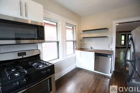 A kitchen with a black stove top oven and a black microwave above it.