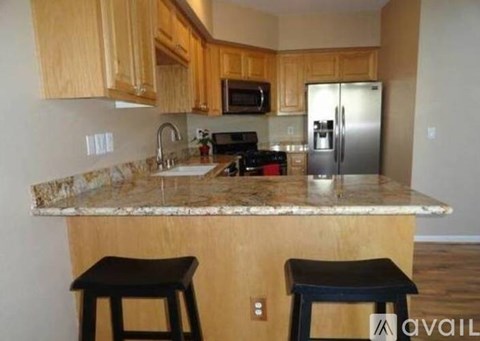 A kitchen with wooden cabinets and granite countertops.