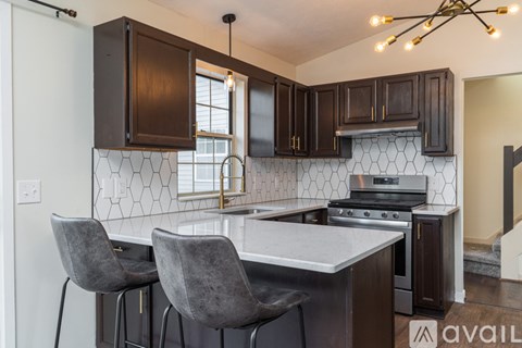 A kitchen with a white counter top and dark brown cabinets.