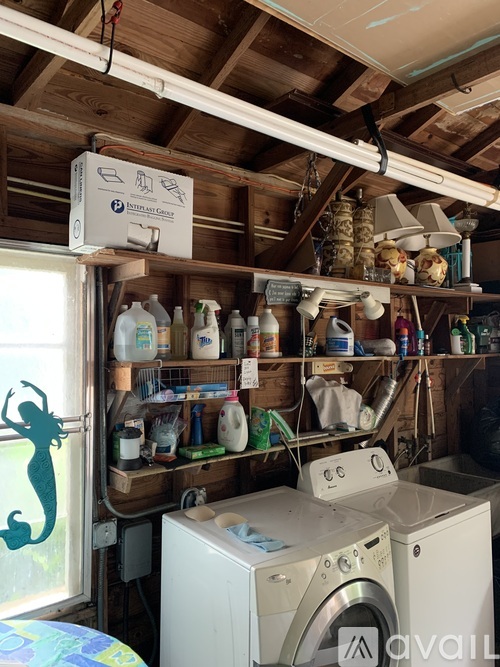 A laundry room with a washer and dryer and a shelf with cleaning supplies.