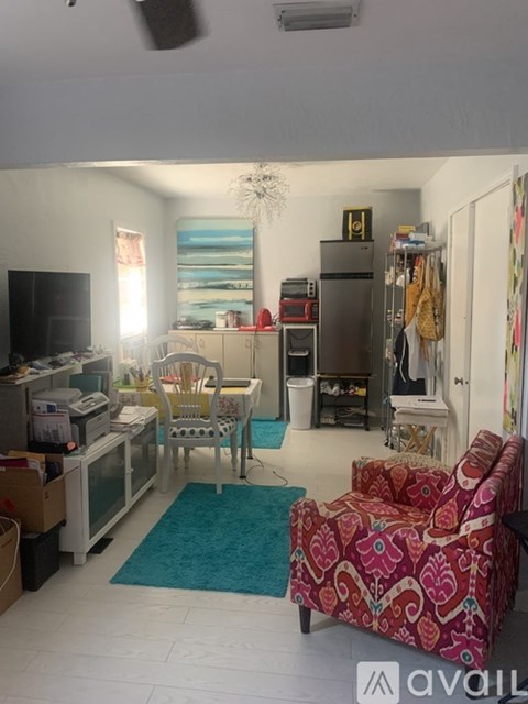 A living room with a red and white patterned chair in the foreground.