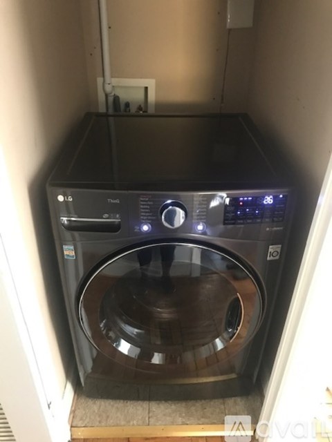 A small LG front loading washing machine sits in a narrow space.