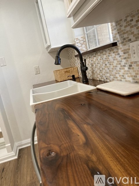 A kitchen with a wooden counter top and a white sink.