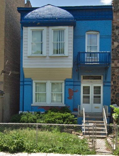 A blue house with a white door and windows.