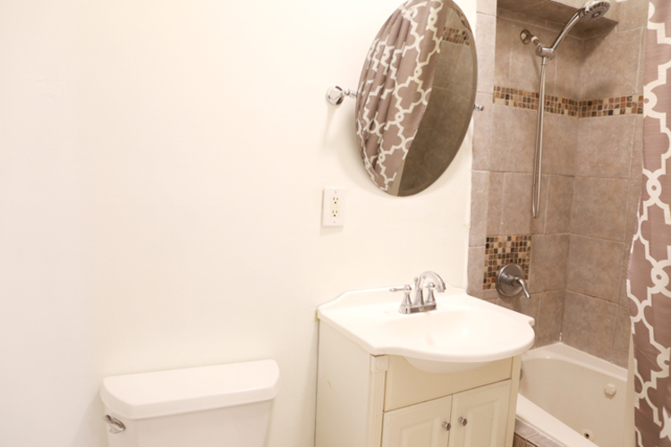 A bathroom with a toilet, sink, and shower.