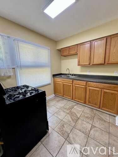 A kitchen with wooden cabinets and a black stove top.