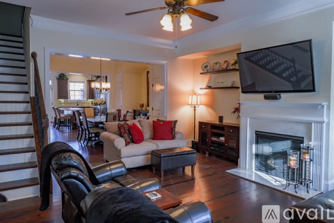A living room with a fireplace and a television on the wall.