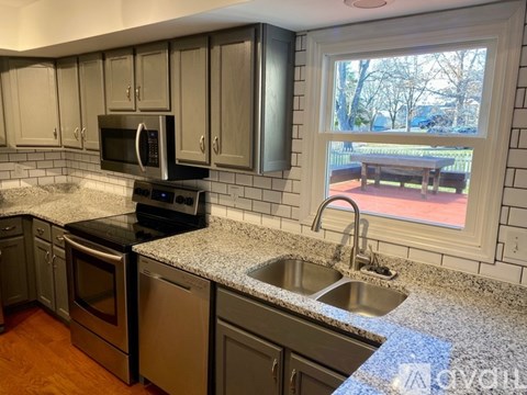 A kitchen with a black stove top oven and a black microwave.